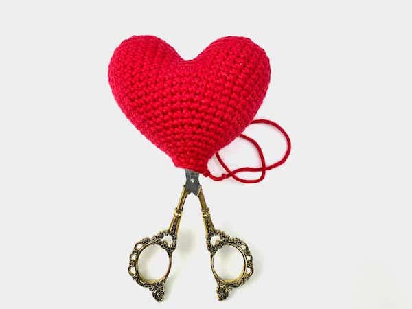 a red crochet heart and a pair of scissors