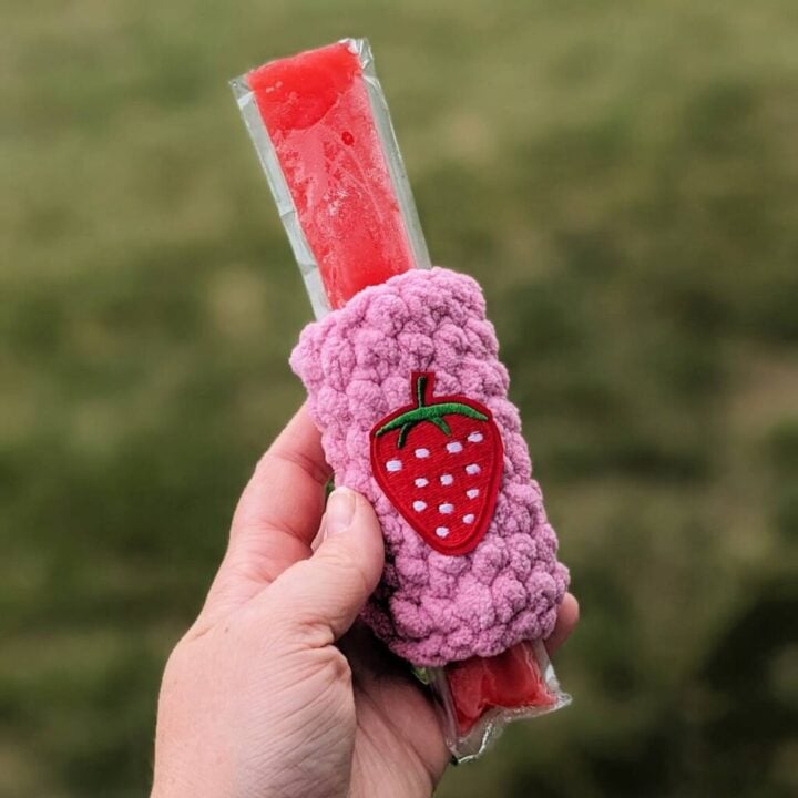 hand holding a red ice pop