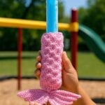 Close-up of kid's hands holding a freeze pop in a pink crochet holder
