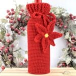 Front view of the crochet wine bottle cozy with textured ribbed stitches and holiday bottle inside.
