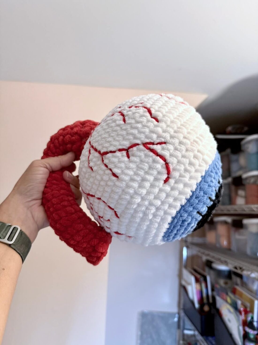 Crochet eyeball pattern finished in plush style, showing detailed veins and red optic nerve for Halloween décor.
