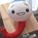 Oversized Amigurumi crochet eyeball plushie with blue iris, made with soft chenille yarn, perfect for spooky Halloween craft.