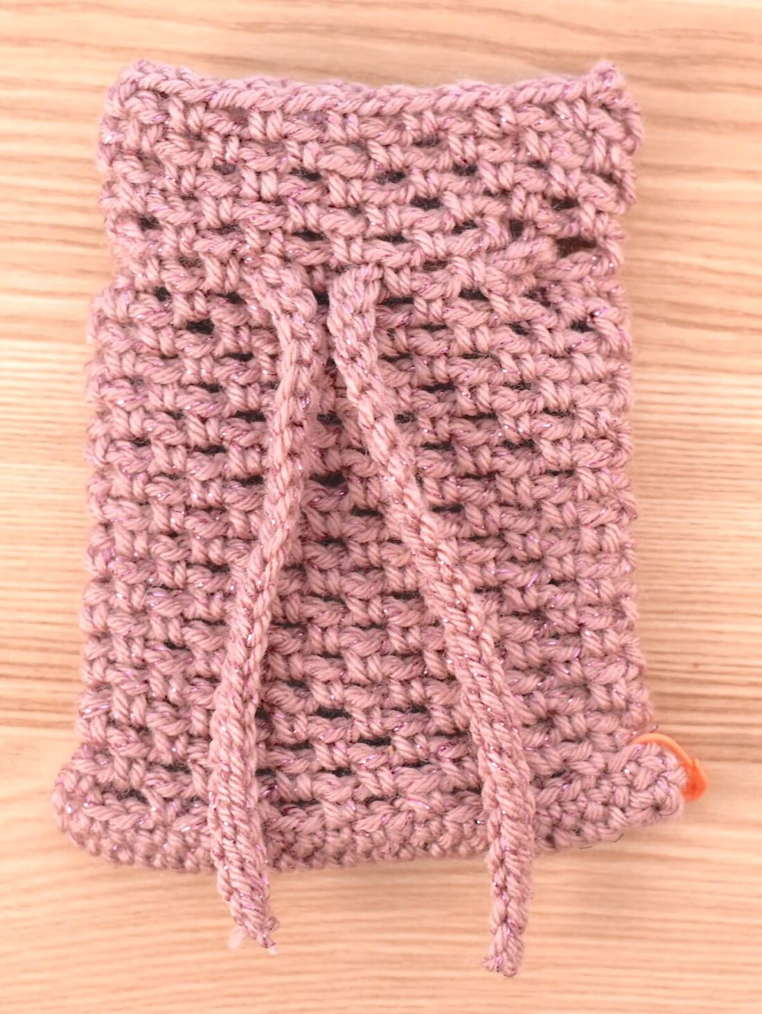 Close-up of the completed crochet bag after, with the string inserted.