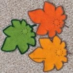 Colorful crochet maple leaves displayed flat on a neutral background.