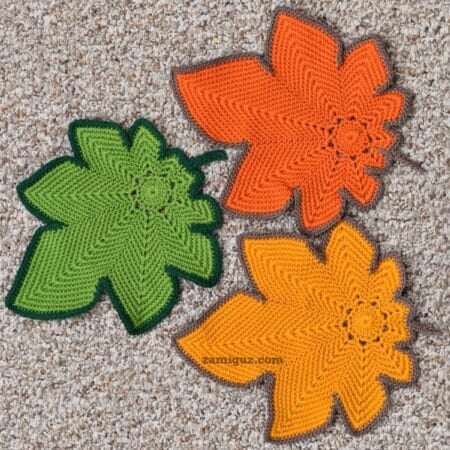 Colorful crochet maple leaves displayed flat on a neutral background.