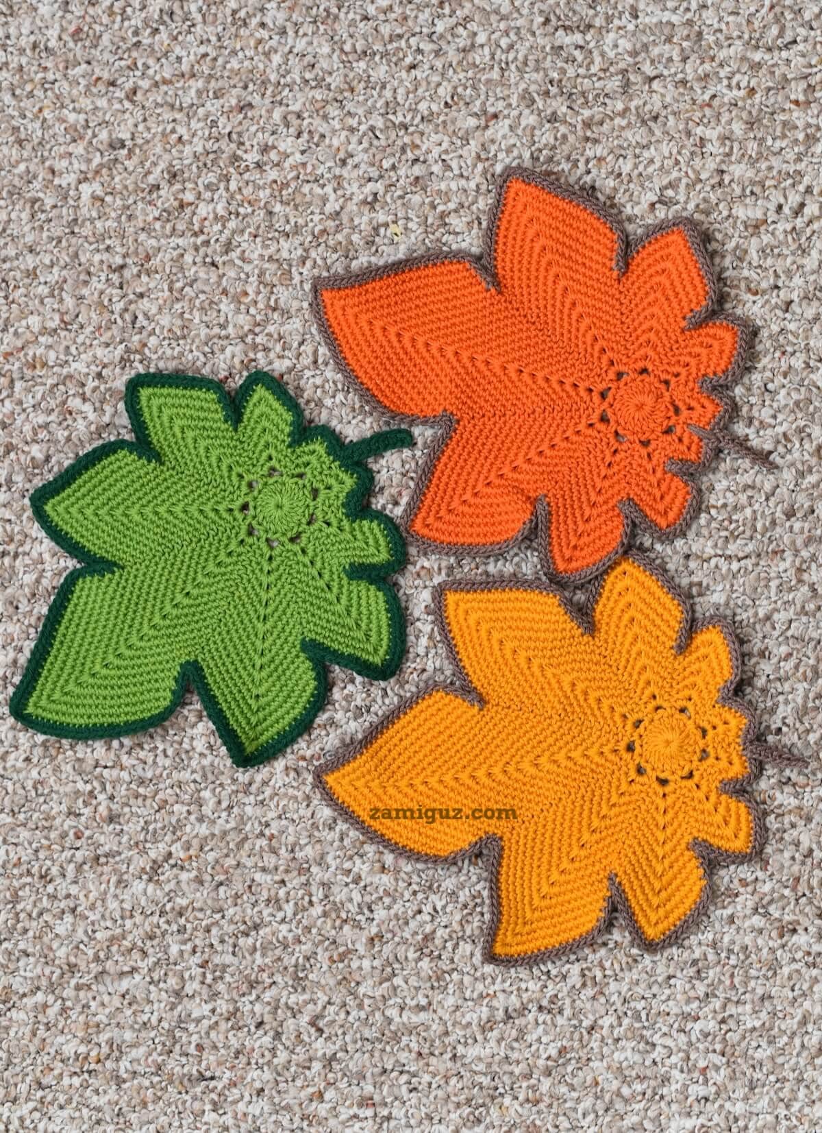 Colorful crochet maple leaves displayed flat on a neutral background.