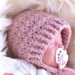 Life-like reborn doll wearing the crocheted baby bonnet