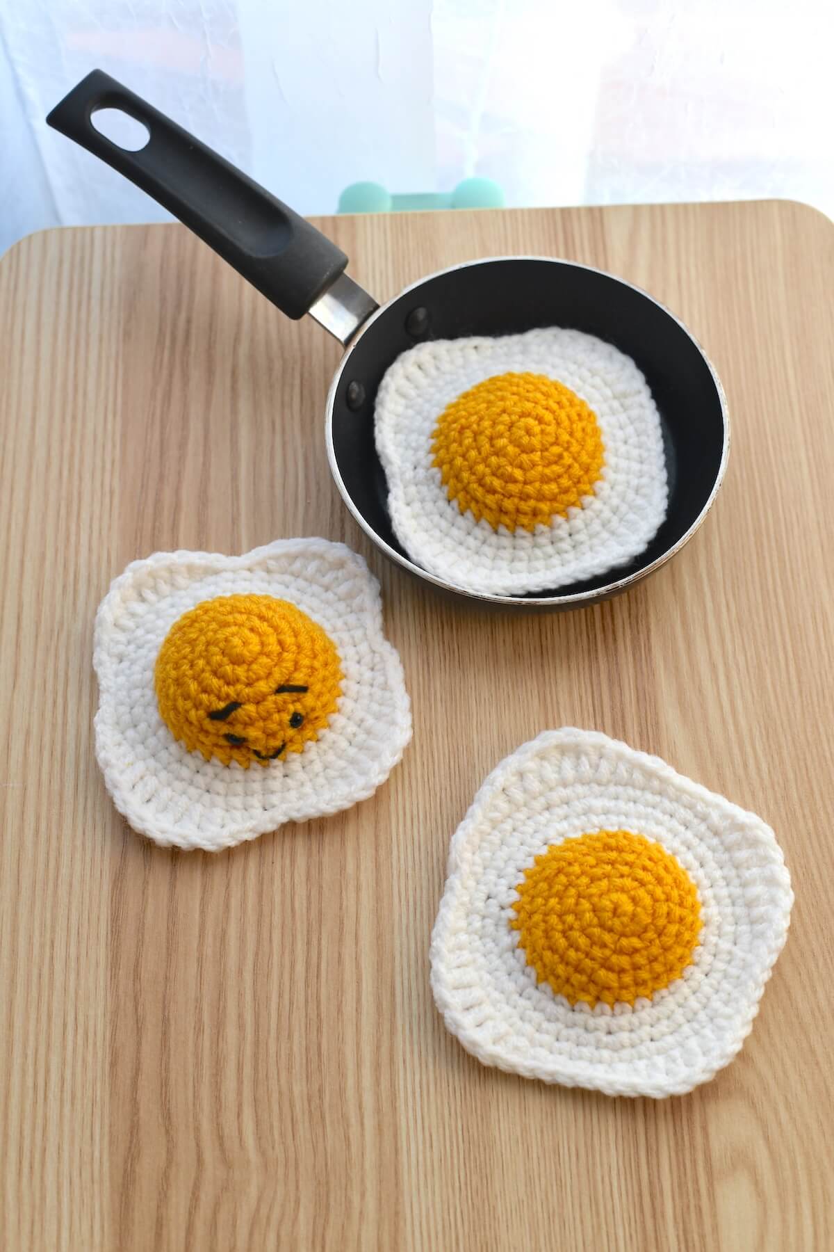 Amigurumi-style crochet fried egg with soft texture and bold yellow yolk.