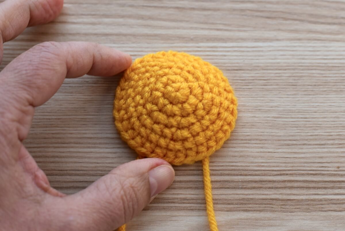 Crocheting the raised yolk for the crochet fried egg pattern.
