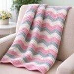 Pastel crochet ripple blanket draped over a beige accent chair in a bright living room.