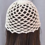 Back view of a crochet skull cap on a brunette manequin