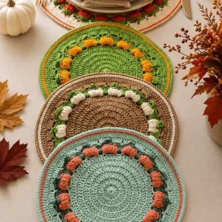 A crochet pumpkin placemat set in two sizes is decorating a Thanksgiving dining table.